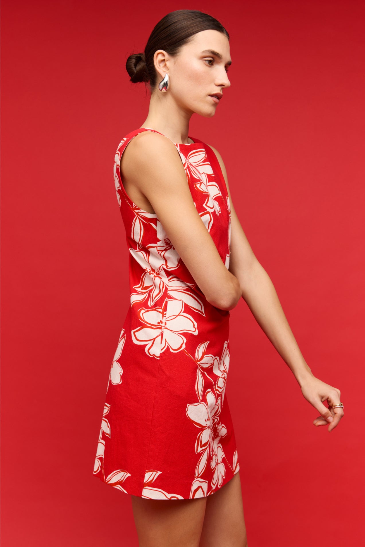 Woman wearing a red dress with white floral pattern on a red background