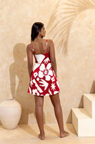 Tahiti mini slip dress from palm collective on a dark skin model against a peach wall. 