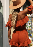 Model wearing rust colour cropped top with frill details