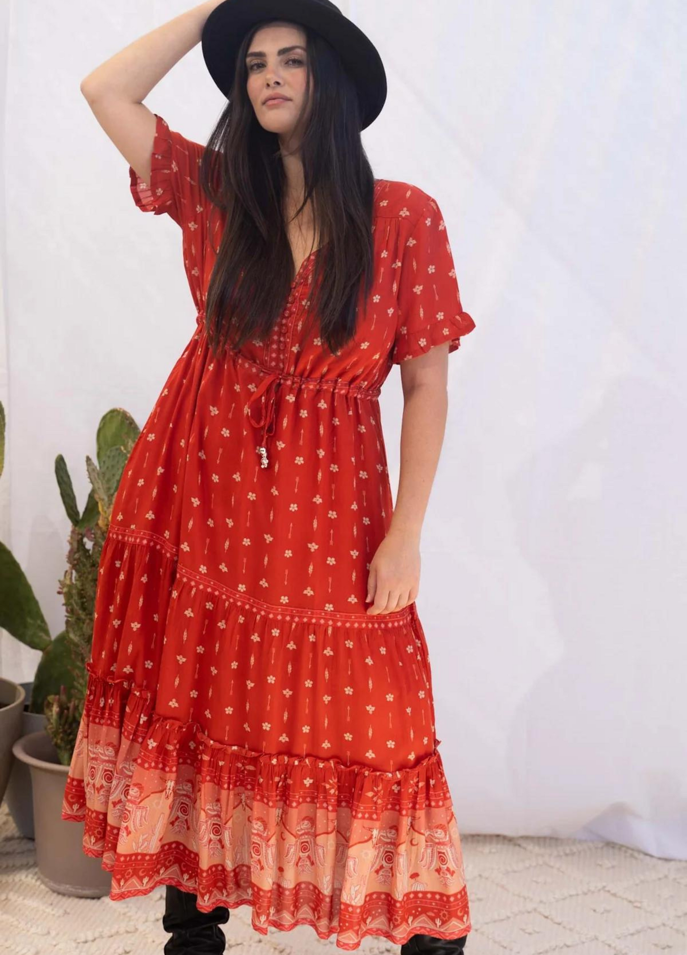 Model wearing a red boho maxi dress with border print at the bottom