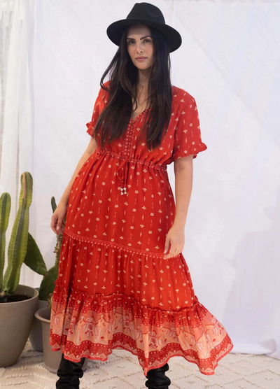 Model wearing a red boho maxi dress with border print at the bottom
