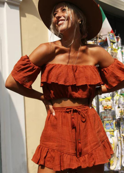 Model wearing rust colour cropped top with frill details