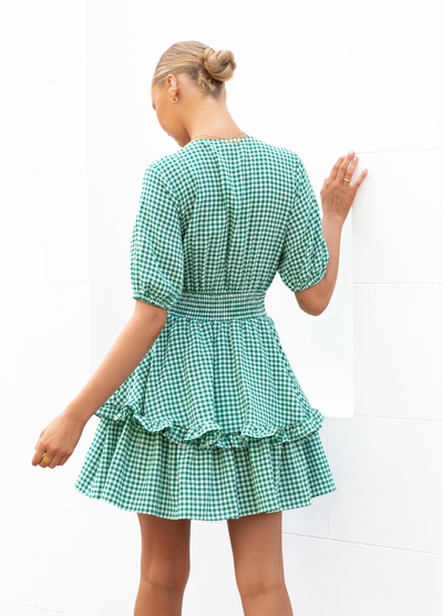 Model wearing green gingham mini dress from Paper Heart