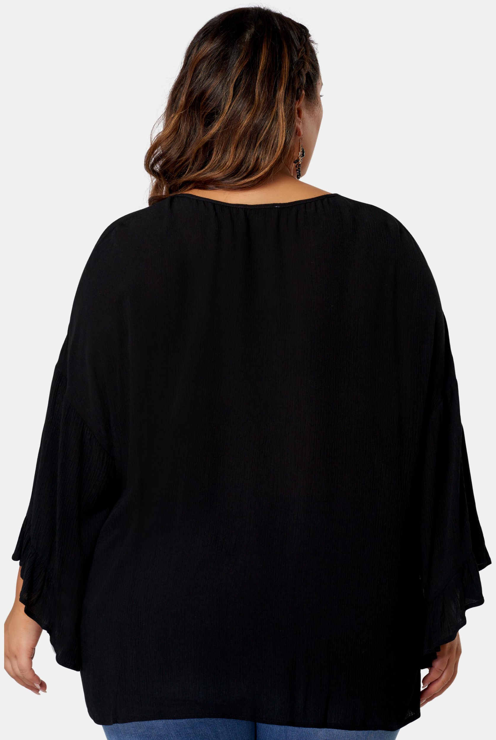 Woman wearing black boho blouse from the back