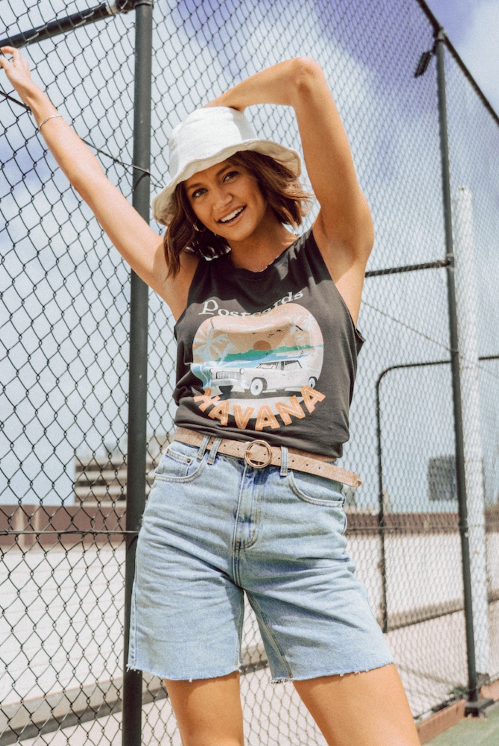 Model wearing light wash short with postcards tee