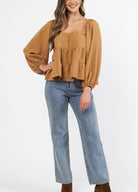 Woman wearing cinnamon colour trapeze top