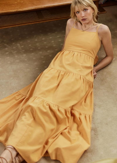 Model wearing orange strappy tiered astrid maxi dress from girl and the sun