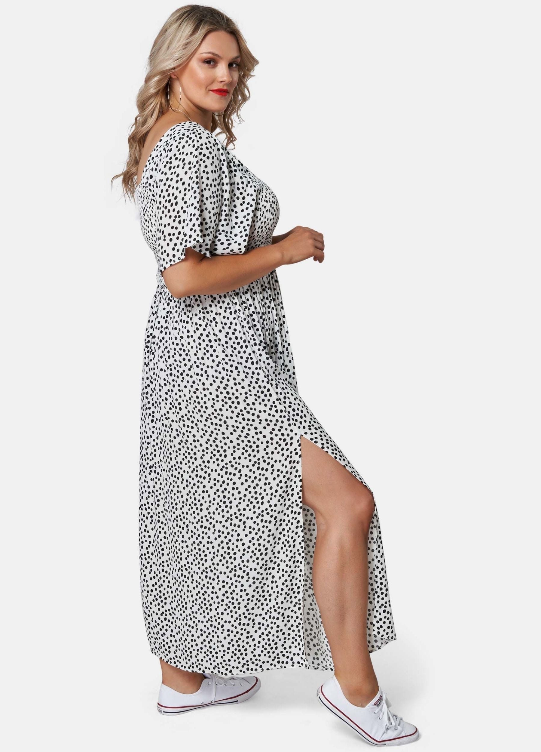 Blonde woman wearing black and white spot maxi dress