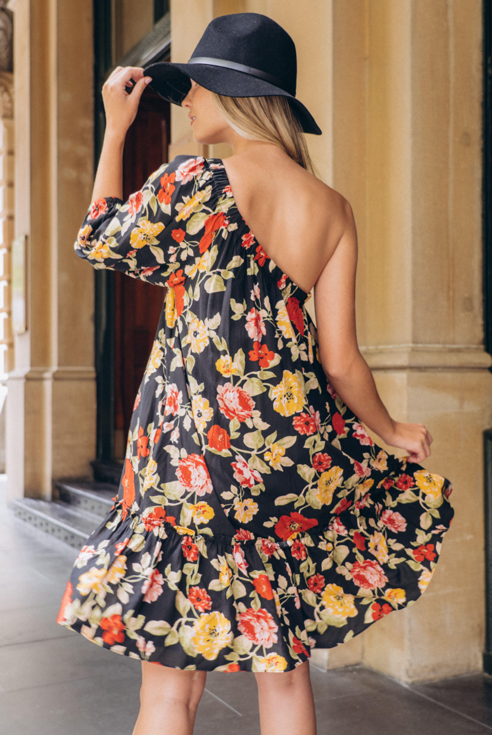 Model wearing the Josephina one shoulder dress in black base floral print