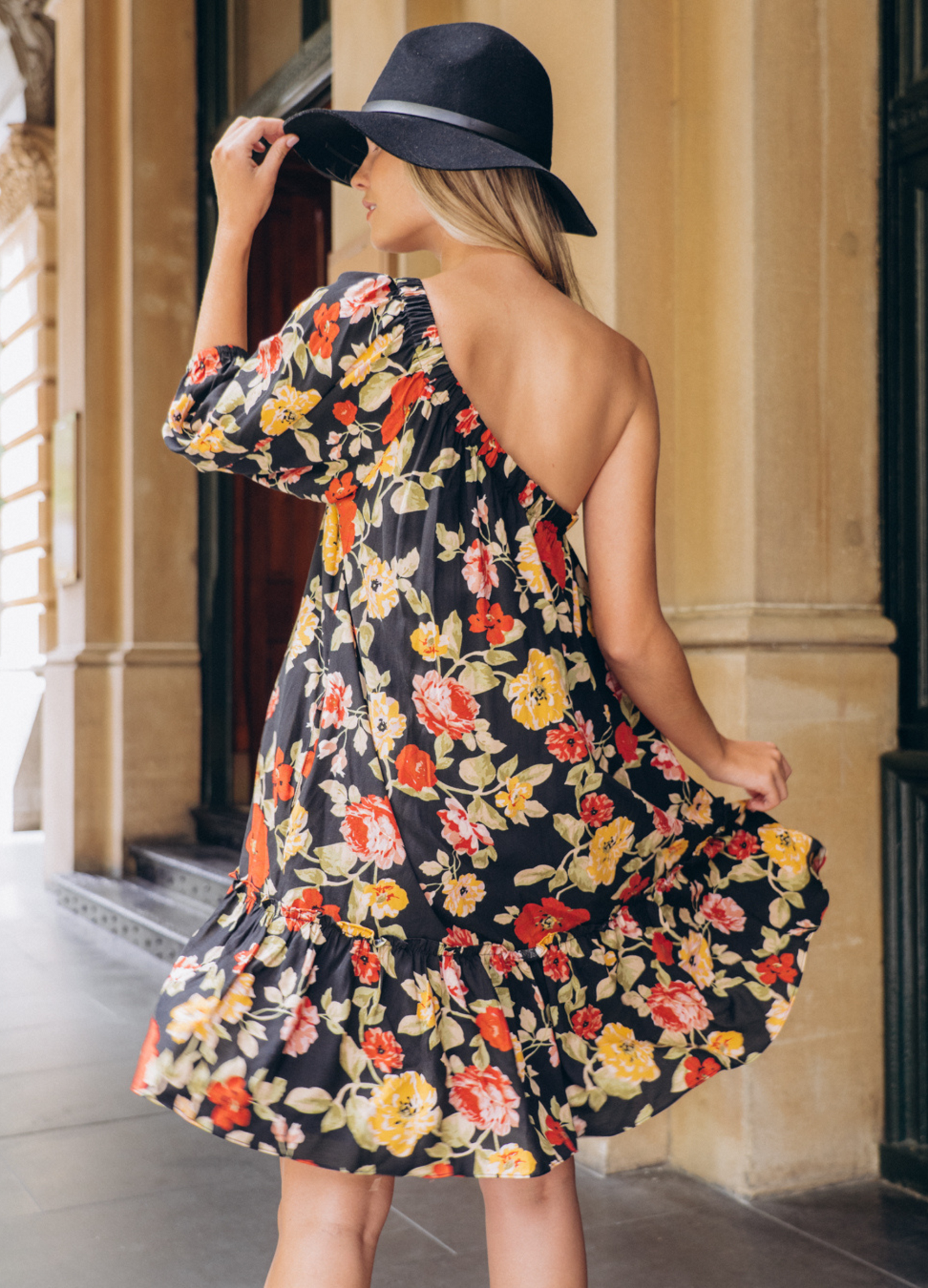 Model wearing the Josephina one shoulder dress in black base floral print