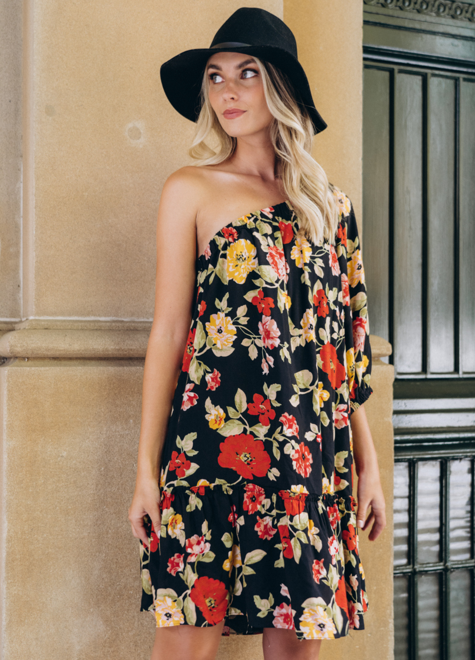 Model wearing the Josephina one shoulder dress in black base floral print