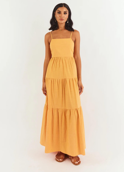 Model wearing orange strappy tiered astrid maxi dress from girl and the sun