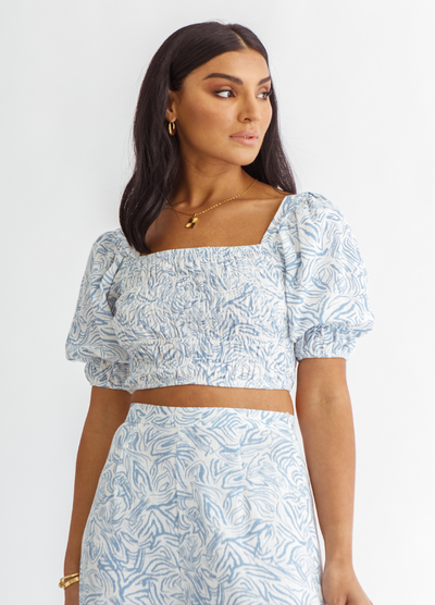 Woman wearing blue and white wave print top