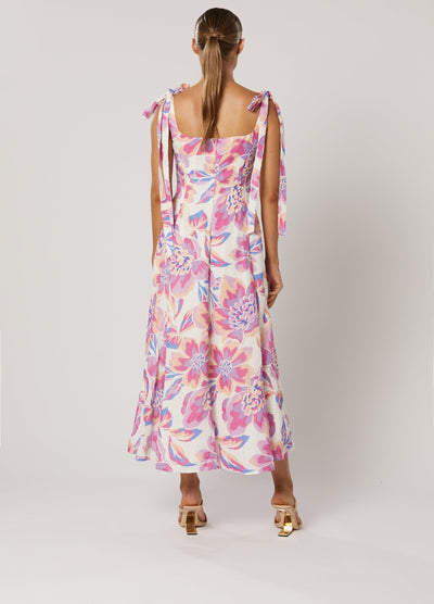 Model wearing the Audra Print Midi Dress in pretty pink floral print with tie shoulder straps