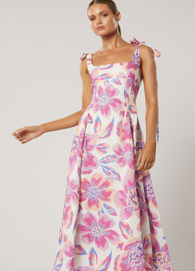 Model wearing the Audra Print Midi Dress in pretty pink floral print with tie shoulder straps