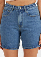 Woman wearing denim shorts in mid wash