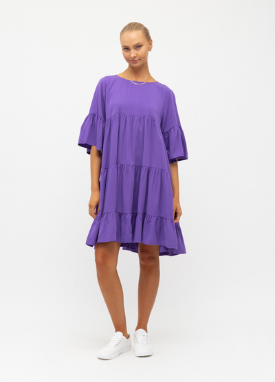 Model wearing purple tiered dress with a flattering mid length sleeve from label of love