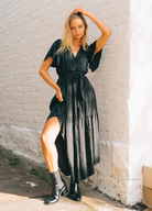 Model wearing black arabella maxi dress with short sleeve, wrap top and waist belt