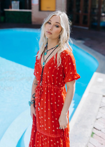 Model wearing a red boho maxi dress with border print at the bottom