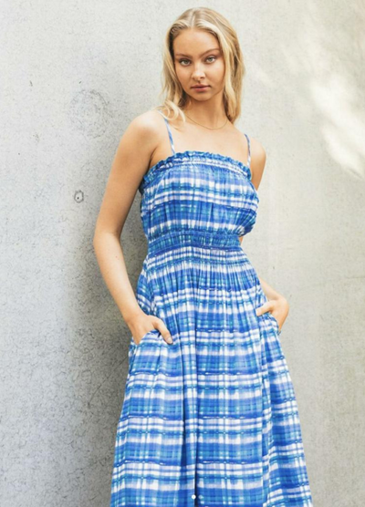 Model with blonde hair wearing blue check dress with thin straps and side splits