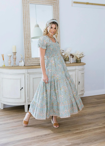 Model wearing the house of skye Daisy Belle dress in floral print with shirred bust and puff sleeve