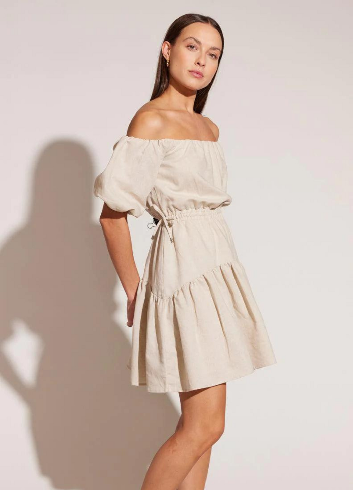 Model wearing the Isola beige off shoulder linen dress with a line hem