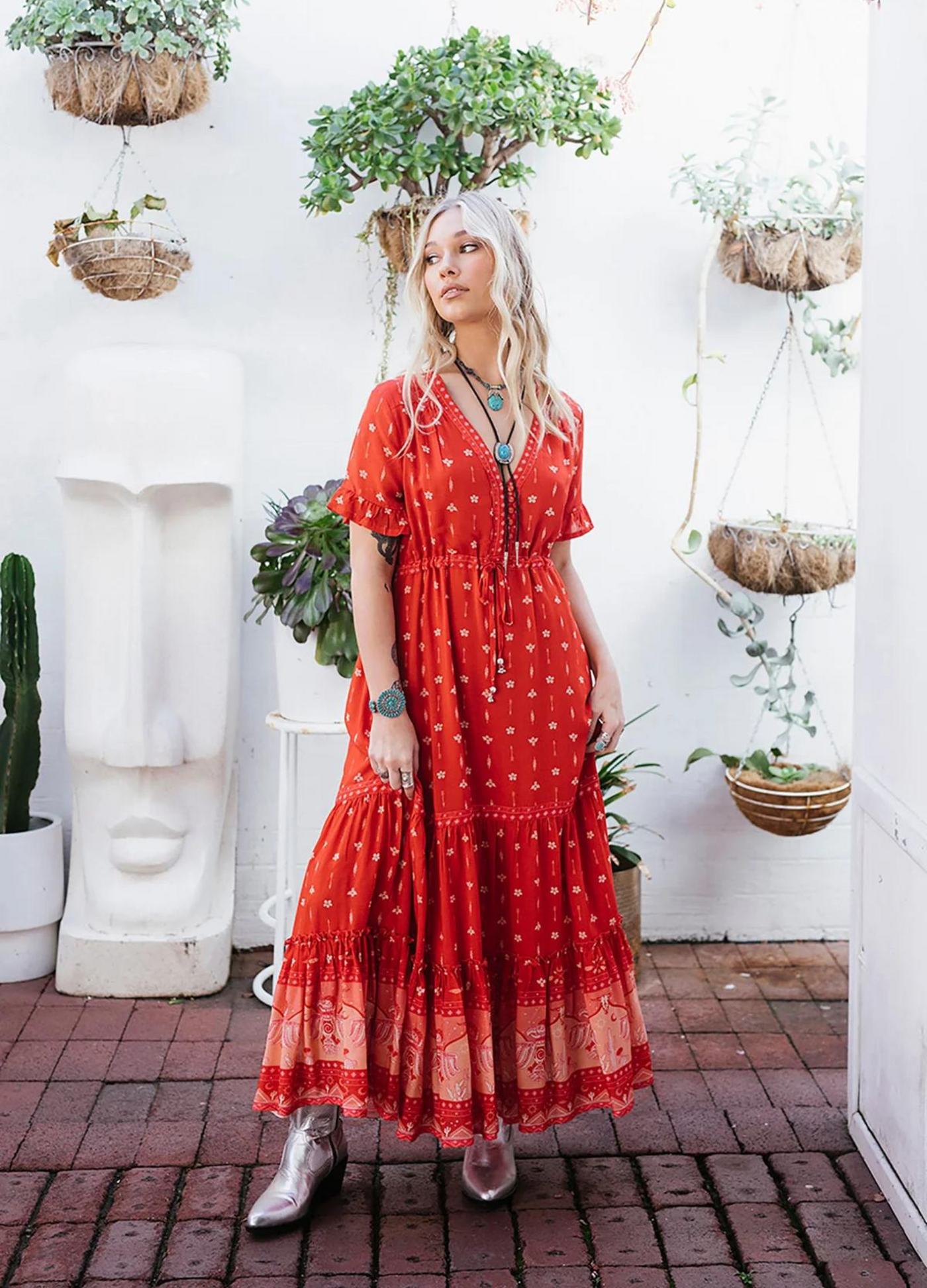 Model wearing a red boho maxi dress with border print at the bottom