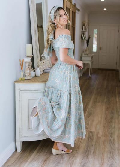 Model wearing the house of skye Daisy Belle dress in floral print with shirred bust and puff sleeve