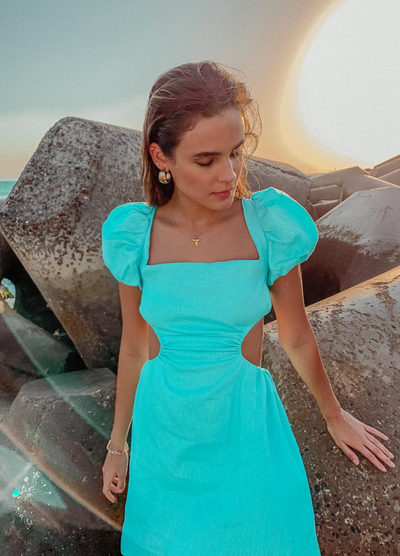 Brunette model wearing the arametta dress in aqua
