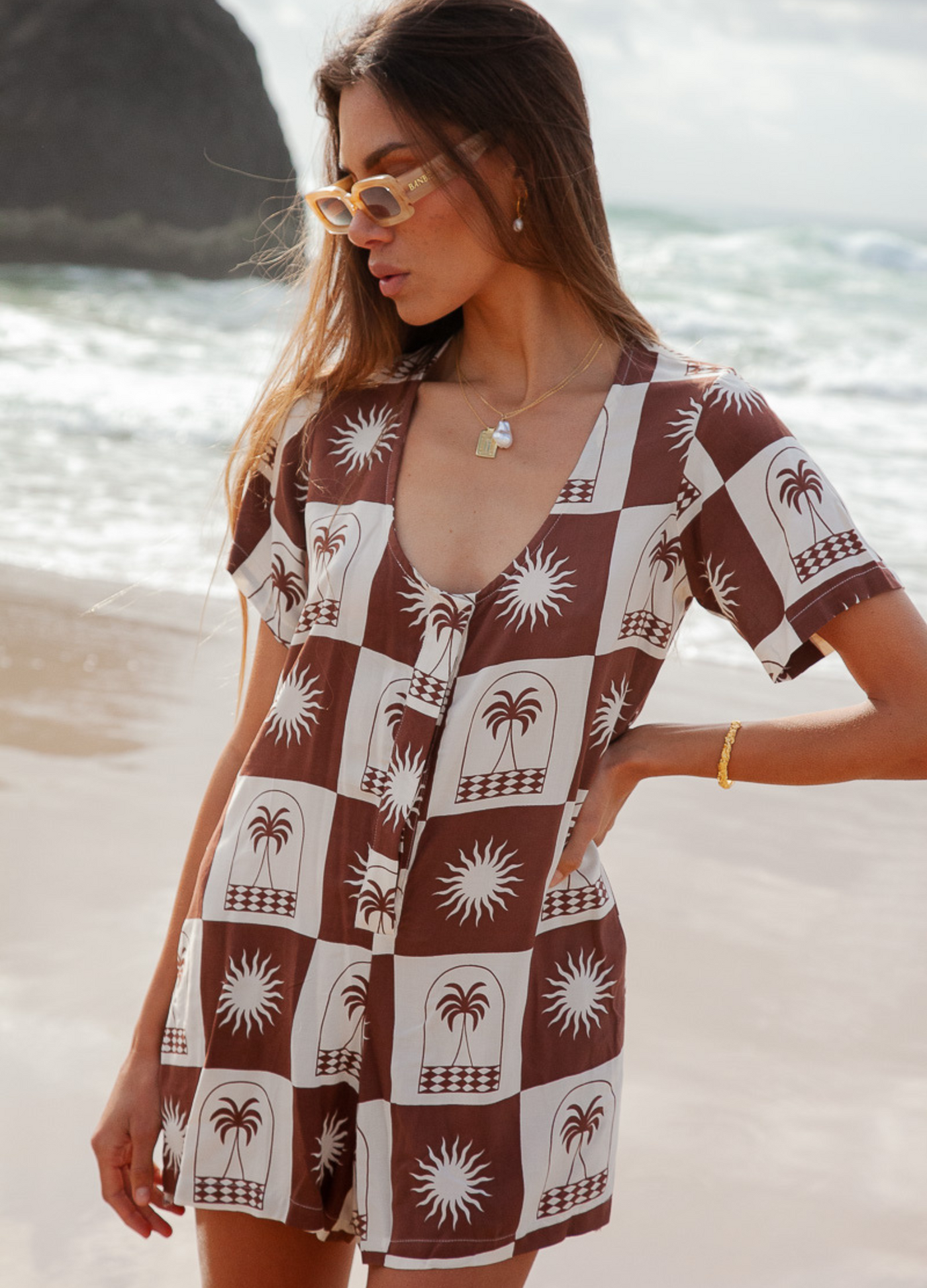 Woman wearing a chocolate and white palm print playsuit 