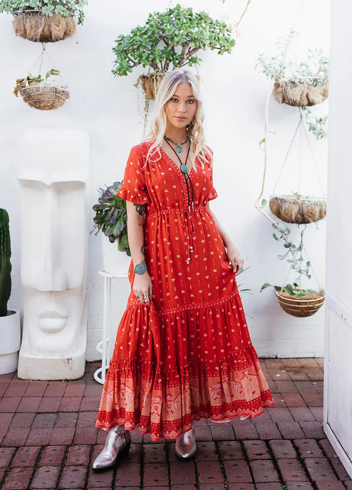 Model wearing a red boho maxi dress with border print at the bottom