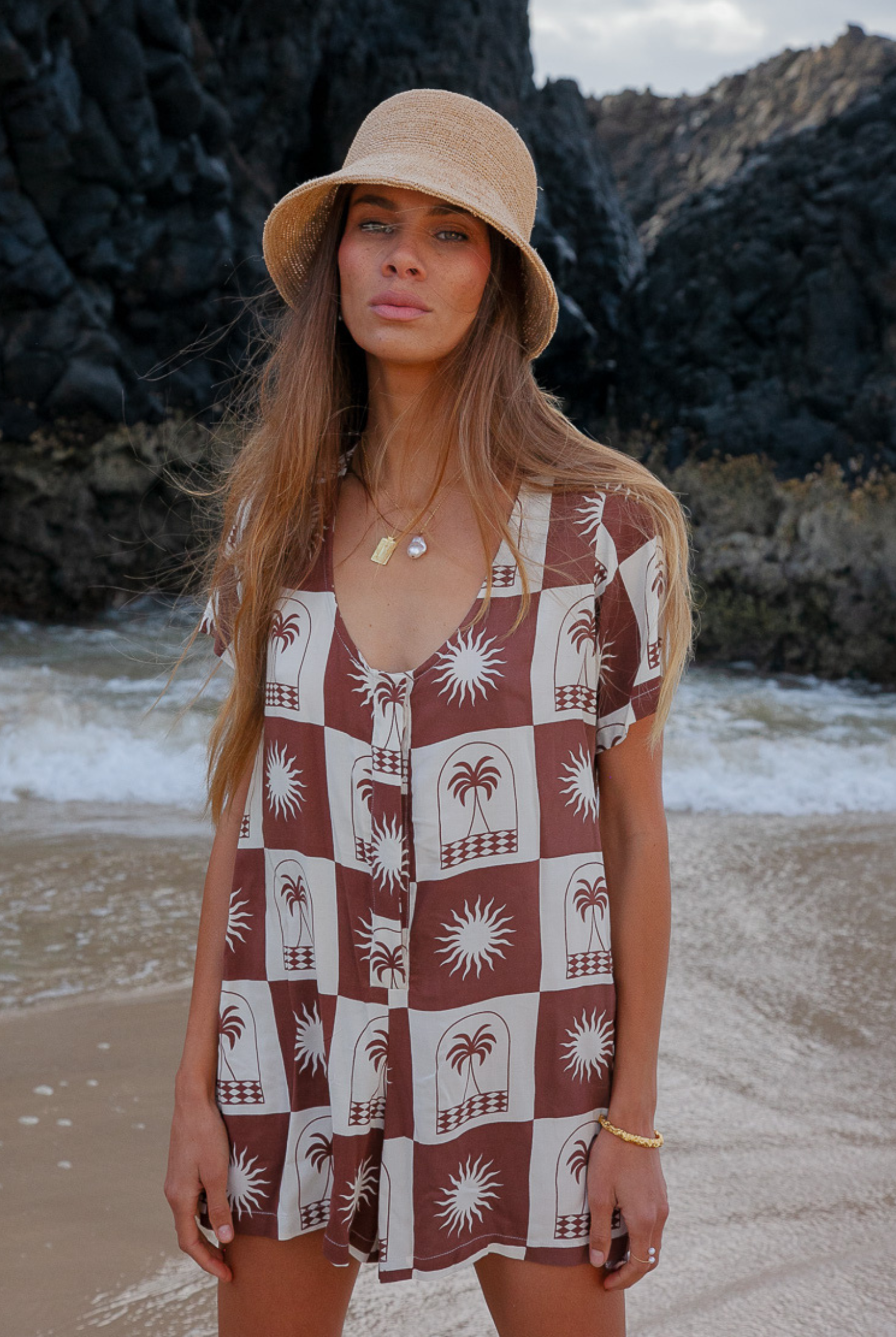 Woman wearing a chocolate and white palm print playsuit 