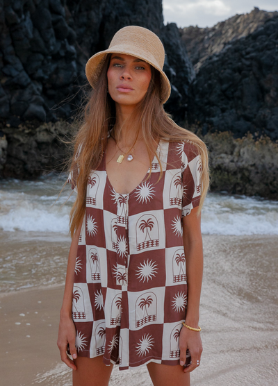 Woman wearing a chocolate and white palm print playsuit 