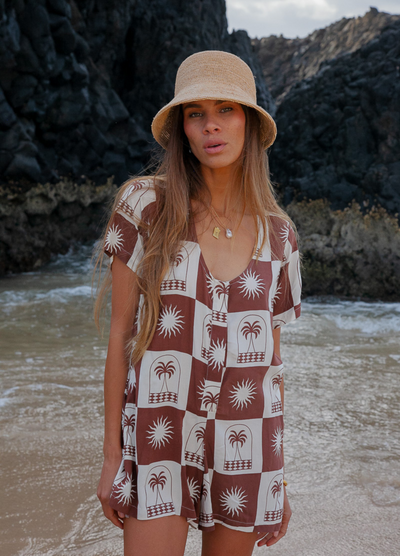 Woman wearing a chocolate and white palm print playsuit 