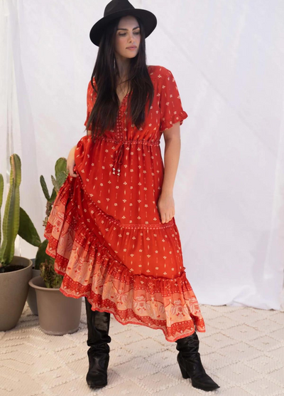 Model wearing a red boho maxi dress with border print at the bottom