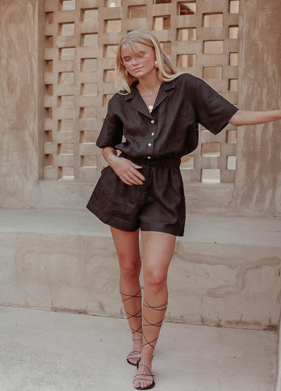 Woman with blonde hair wearing black linen playsuit