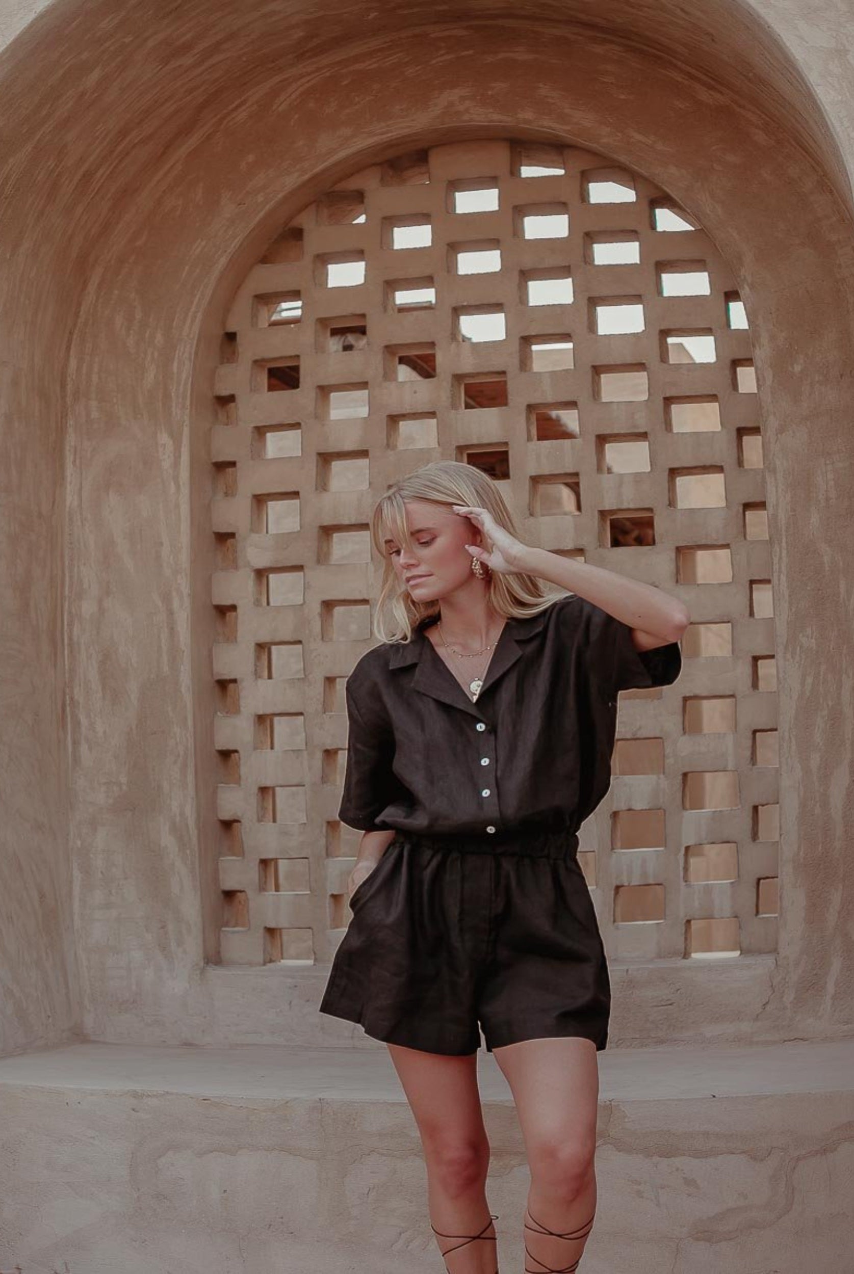 Woman with blonde hair wearing black linen playsuit