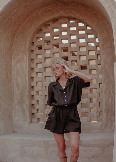 Woman with blonde hair wearing black linen playsuit