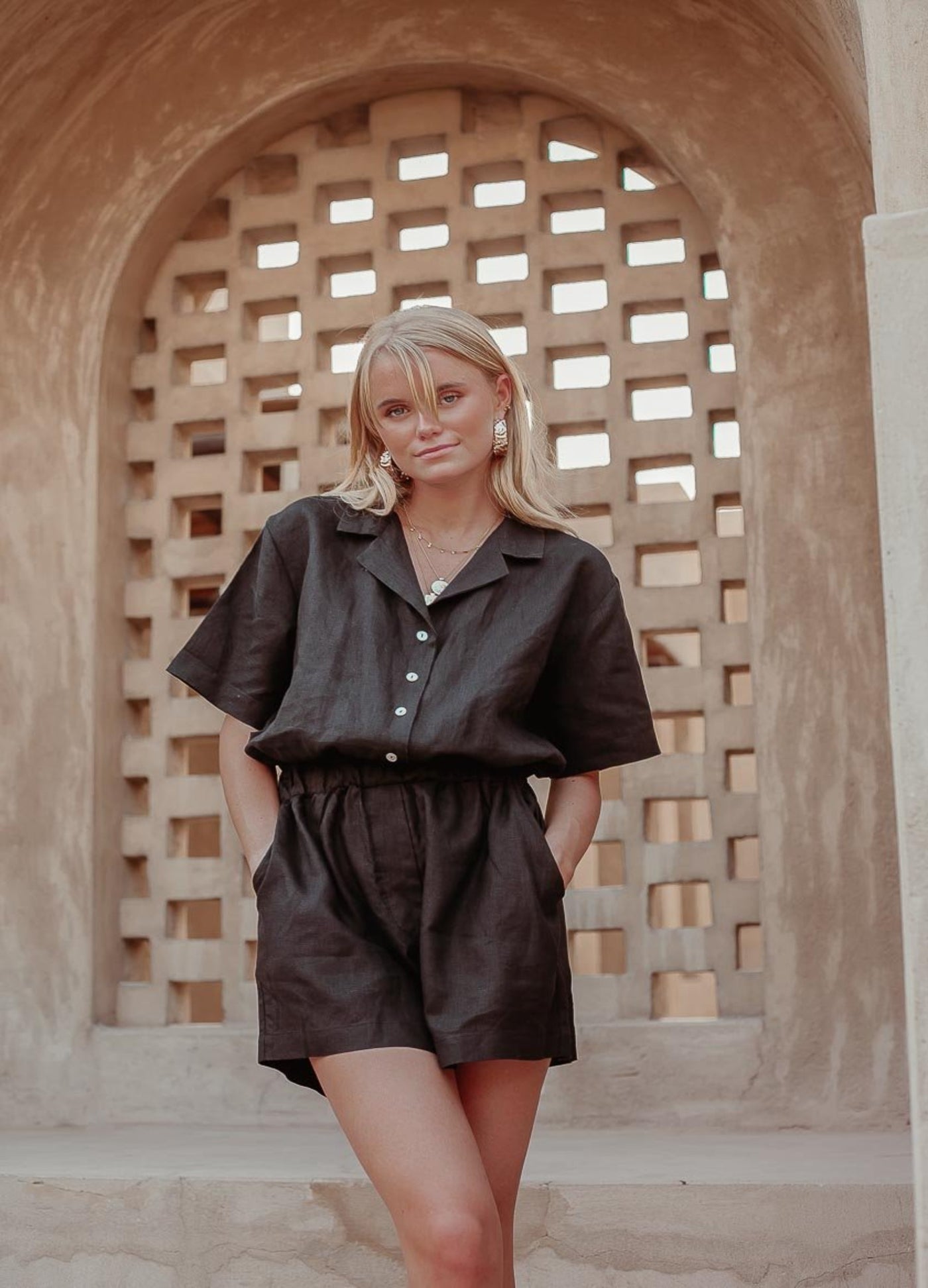 Woman with blonde hair wearing black linen playsuit