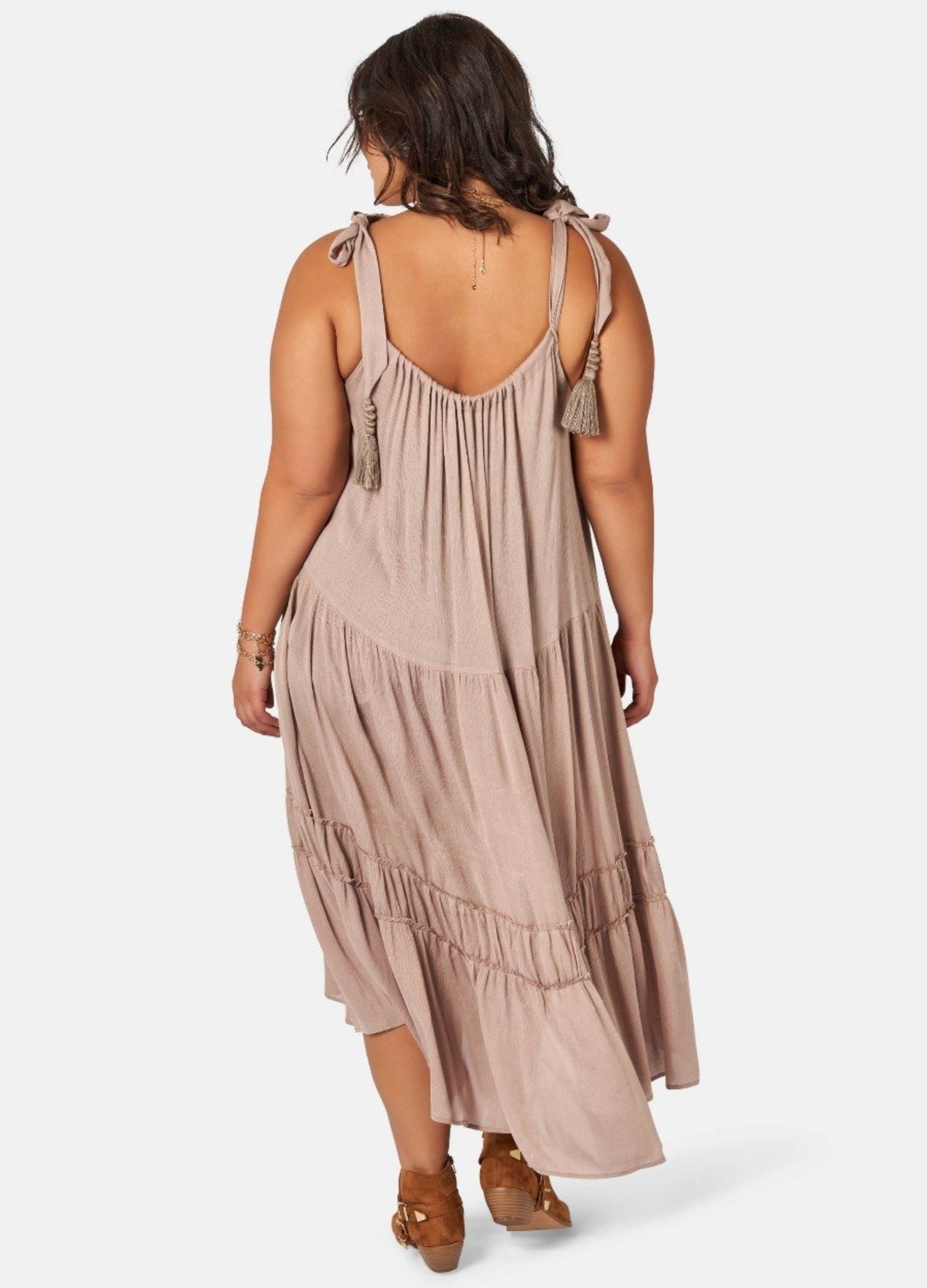 Model wearing nude maxi dress with asymmetric hemline