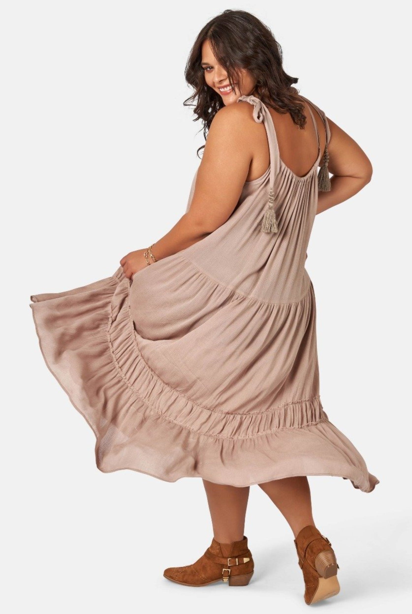 Model wearing nude maxi dress with asymmetric hemline
