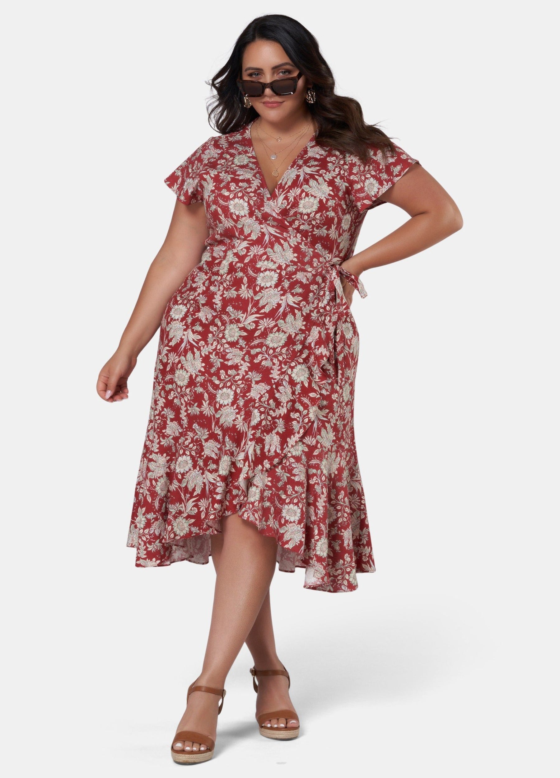 Brunette model wearing red base floral print wrap dress