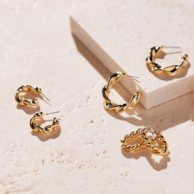 Selection of Gold Hoops pictured on a cream surface