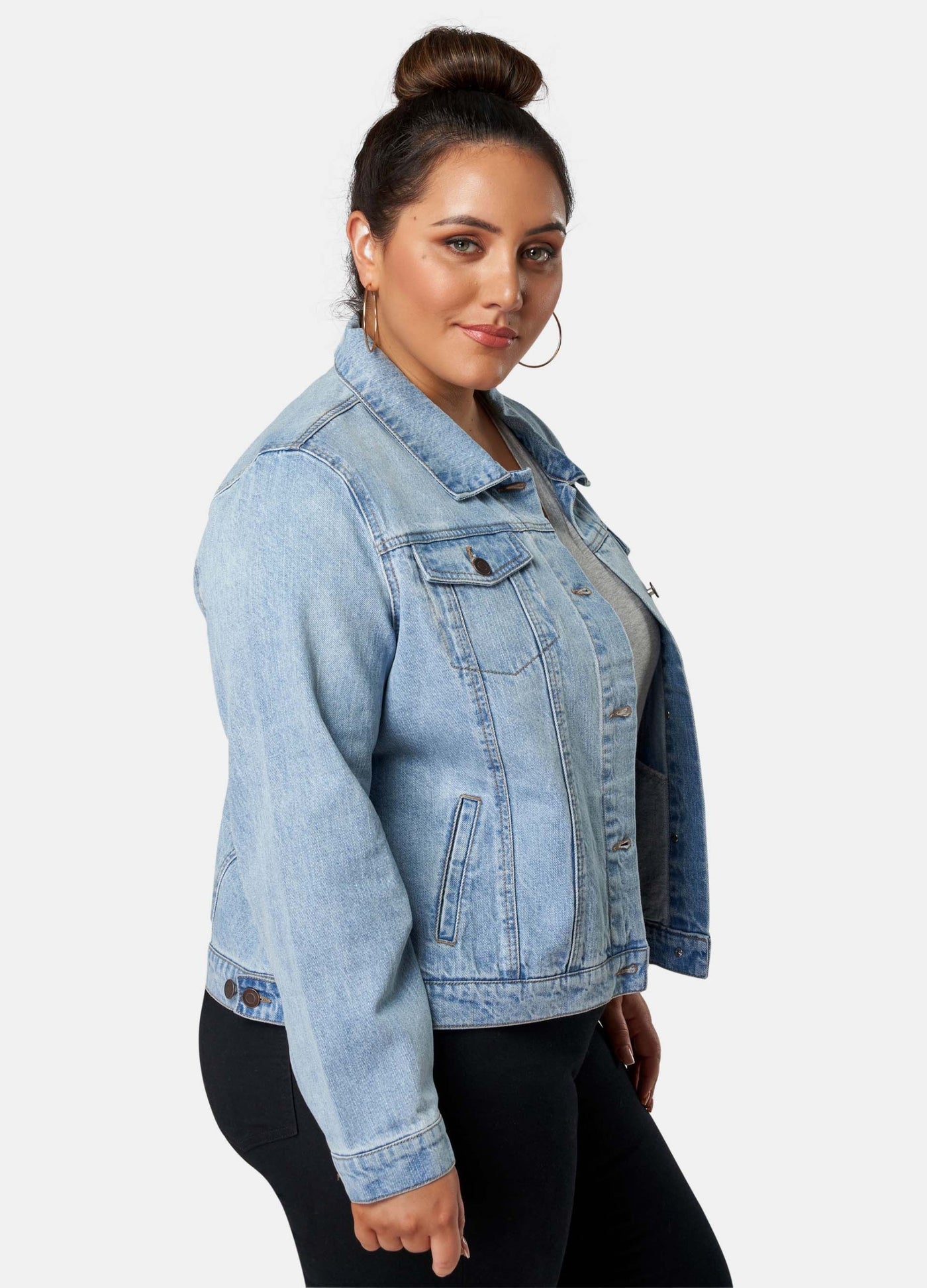 Curvy Model wearing black skinny jeans, grey top and denim jacket
