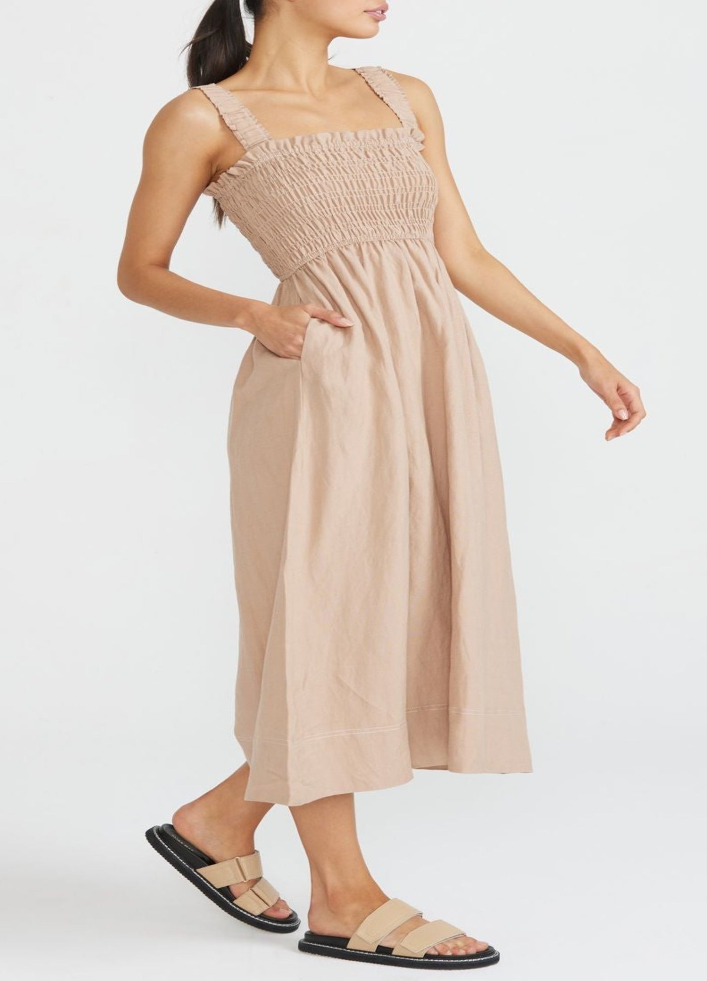 Model wearing shirred midi dress in neutral colour