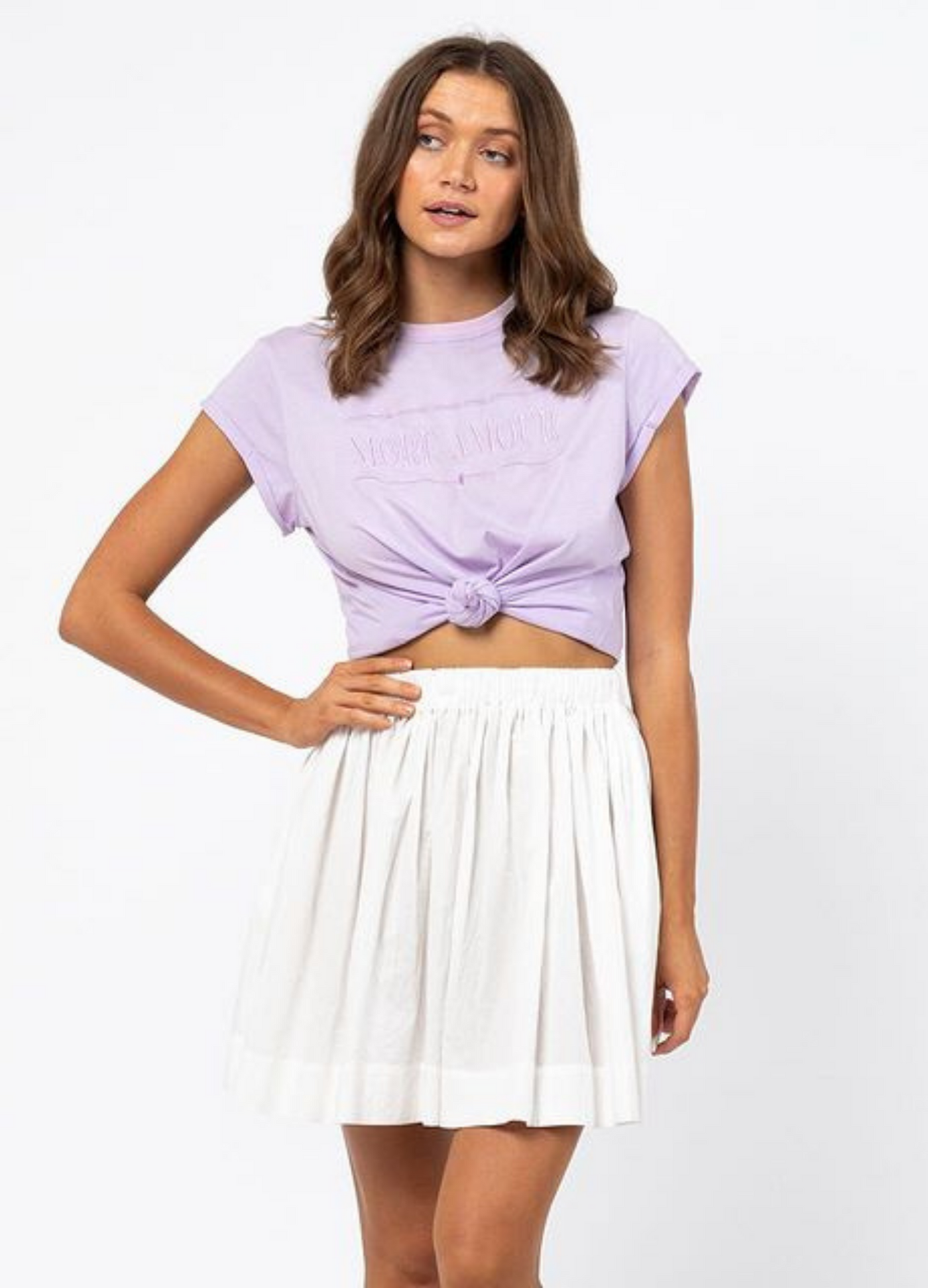 Woman wearing lilac tshirt and white skirt