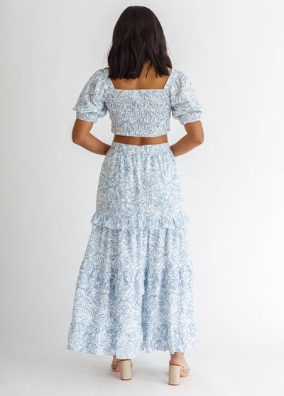 Woman wearing blue and white wave print top from the back