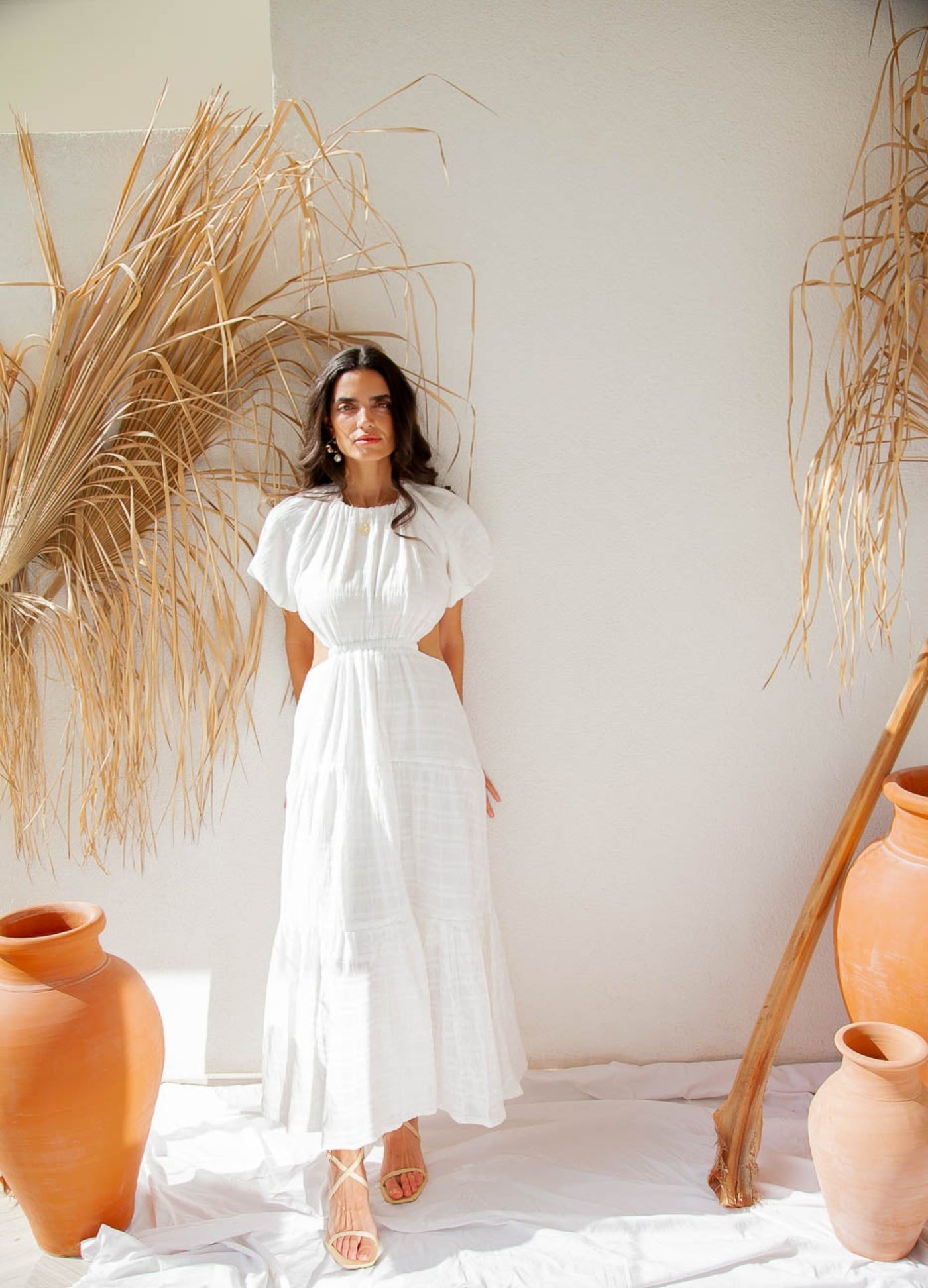 Woman standing by wall wearing maxi dress