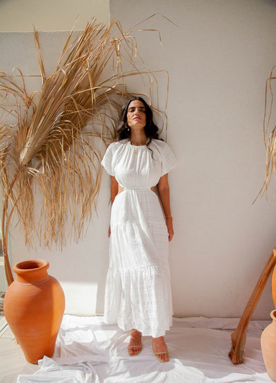 Woman standing by wall wearing white maxi dress
