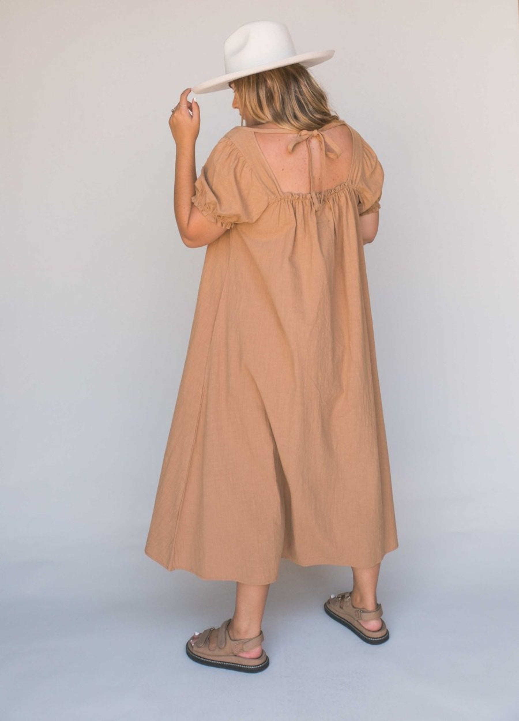 Model shot from the back wearing beige midi dress